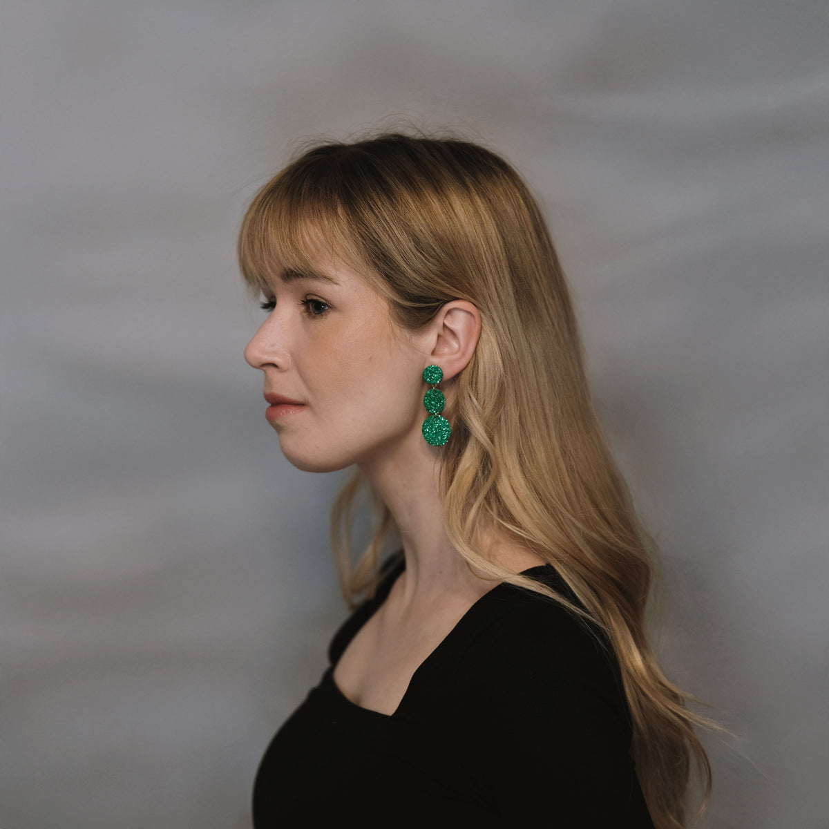 LEMPI®-korvakorut käytössä – Ilona-malli vihreänä versiona korvassa sivusta kuvattuna.